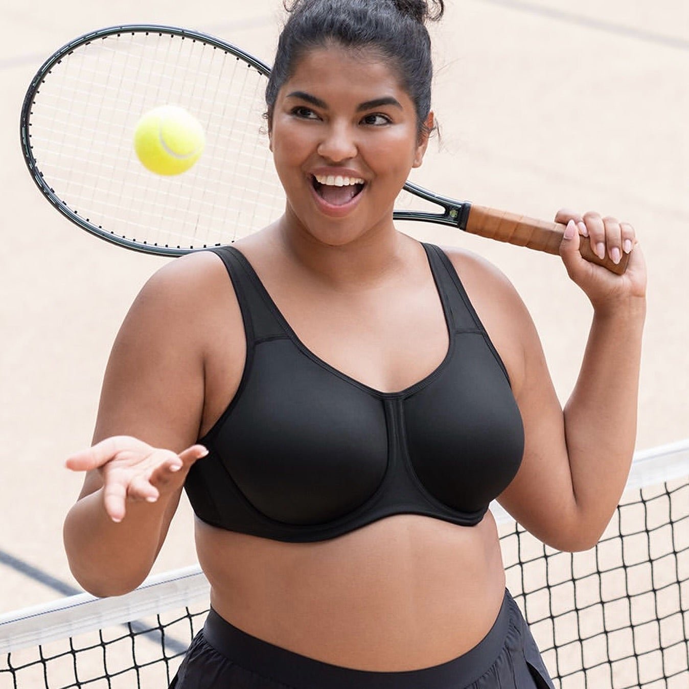 lady holding a tennis racket wearing the Wacoal Simone High Impact sports bra